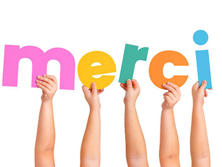 Enfant tenant un panneau "Merci"