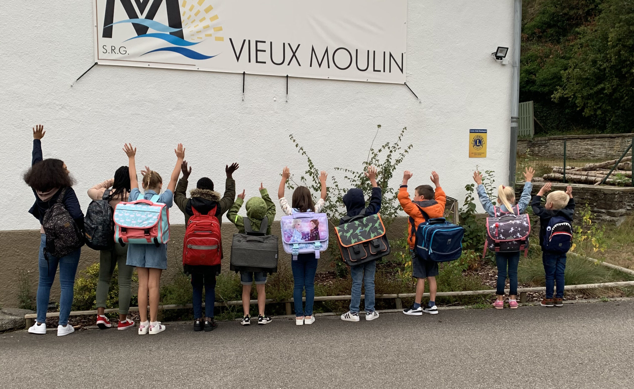 Groupe d'enfant devant un vieux moulin.